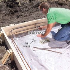 a man kneeling down on top of a pile of construction materials next to some wires