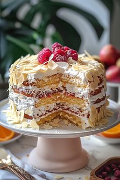 a cake with white frosting and raspberries on top sitting on a plate