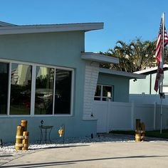 an american flag is flying in front of a house that has been painted blue and white