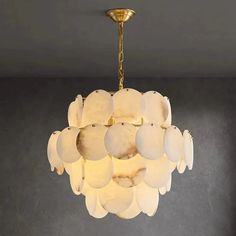 a chandelier hanging from the ceiling in a room with dark walls and flooring