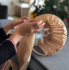 a woman is holding a paper plate with a fan on it and another person's hand