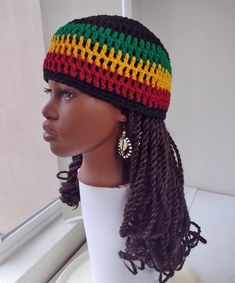 a mannequin head wearing a multicolored knitted hat with braids