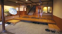 an empty room with wooden flooring and shoes on the ground in front of it