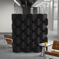 a room divider in an office with two chairs and a table next to it