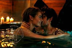 two people in a hot tub with candles on the wall behind them and one person holding his arm around the woman's neck