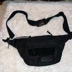 a black fanny bag sitting on top of a white rug