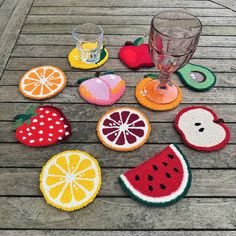 several fruit coasters are sitting on a table with wine glass and watermelon