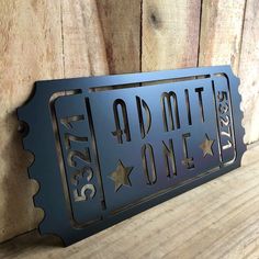 a metal sign that says admit one with stars on the front and back of it