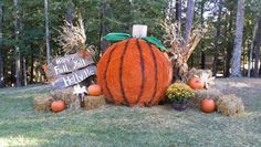 a large pumpkin sitting on top of hay bales