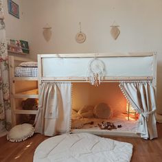 there is a bunk bed with curtains on the top and bottom, next to a stuffed animal