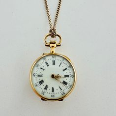 Early 1900s Antique Pocket Watch Boasting A Solid Yellow Gold Case Which Measures ~1" In Diameter. The Watch Face Features A White Enamel Dial With Black Arabic Numerals And Gold Tone Louis Xvi Style Hands. Considering Its Age And Fragility, The Dial Is In Great Condition. No Chips Or Cracks Can Be Found, And All Lettering Is Still Sharp And Clear. The Back Of The Watch Features Lovely Yellow And Rose Gold Inserts And Floral-Themed Engravings. The Back Of The Watch Can Be Opened And Personalized To Your Liking By A Qualified Jeweler. The Watch Is Not Currently Functioning And Requires Service. It Can Be Worn As A Pendant As Shown In The Pictures. The 600-Mm Long Gold Chain Is Also Included. 1800s Antiques, Light Academia Jewelry, Antique Gold Timeless Pocket Watch, Vintage Engraved Gold Pocket Watch, Antique Gold Engraved Pocket Watch, Antique Finish Gold Pocket Watch, Antique Pocket Watch, Face Features, Antique Yellow Gold Self-winding Pocket Watch