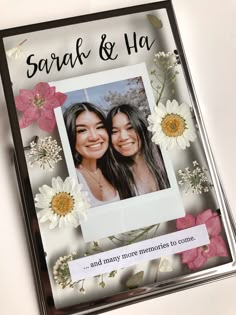 two girls with flowers in front of them on a card