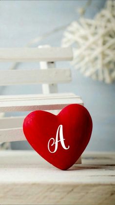 a red heart sitting on top of a white bench