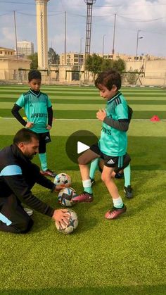 three young boys are playing soccer on the field