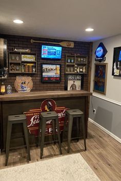 a home bar with stools in the corner and sports memorabilia on the wall behind it