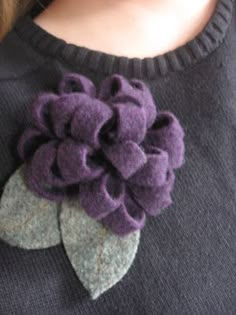 a close up of a person wearing a sweater with a flower on the back of it