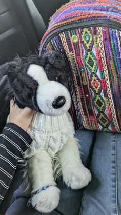 a stuffed animal that is sitting in the back seat of a car next to a pillow