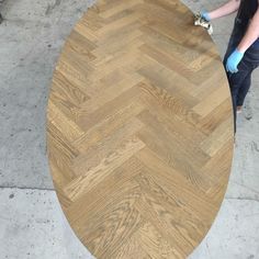 a person sanding down a wooden table top