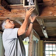 a man is working on the ceiling in his house