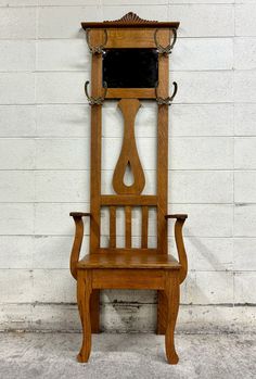 an old wooden chair sitting in front of a white wall with a mirror on it