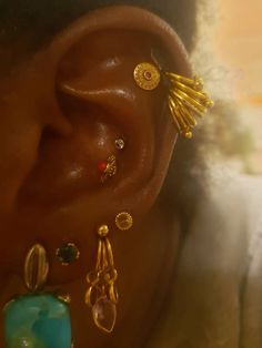 a woman's ear is adorned with earrings