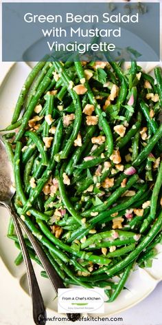 green bean salad with mustard and walnuts in a white bowl on top of a table