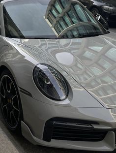 a silver sports car parked on the side of the road in front of other cars