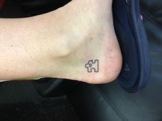 a person with a tattoo on their foot that has two puzzle pieces in the middle