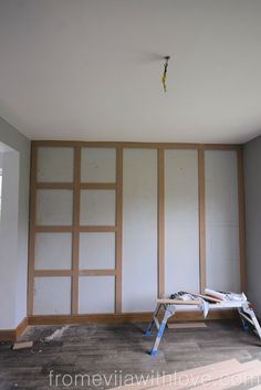 an empty room is being remodeled with white paint and wood paneling on the walls