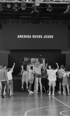 a group of people standing on top of a basketball court with their arms in the air