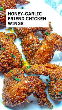 honey - garlic fried chicken wings on a white plate with green sprinkles