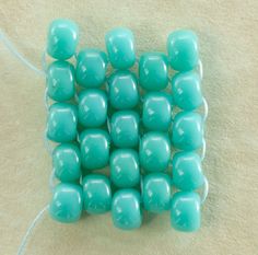 a group of turquoise beads sitting on top of a white surface