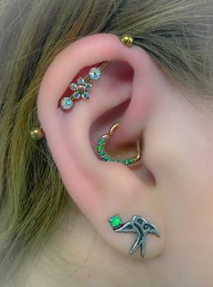 a close up of a person's ear with some piercings on it