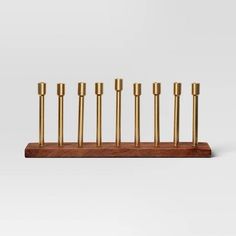 a set of seven brass candles sitting on top of a wooden stand