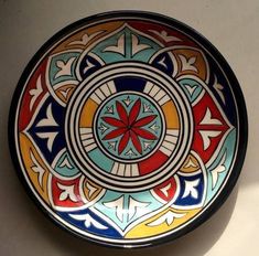 a colorful bowl is sitting on the wall