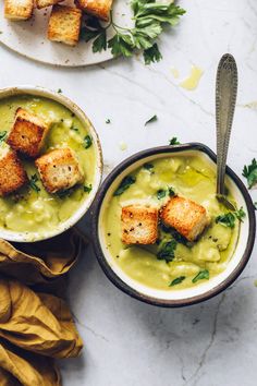 two bowls of soup with croutons and parsley