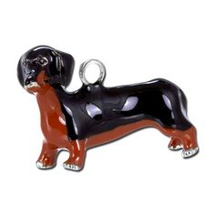 a black and brown dog charm on a white background with a red border around it