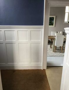 the interior of a house with blue walls and white wainscoting on the wall