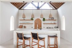 three stools sit in front of an island counter