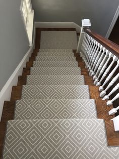 a staircase with carpeted steps and handrails leading up to the second floor