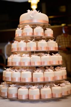 a tiered wedding cake with white and pink cakes on it's bottom layer