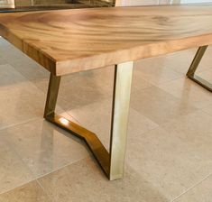 a wooden table sitting on top of a tile floor next to a wall and window