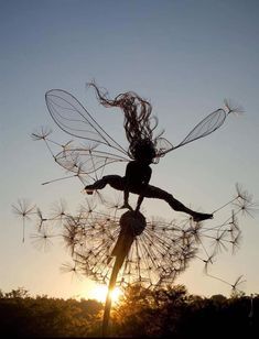 a woman is flying through the air on top of a dandelion