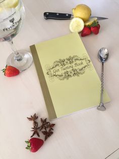 a recipe book sitting on top of a table next to strawberries and lemons