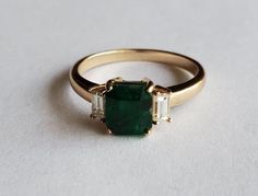 Beautiful dark green natural swat valley emerald with natural baguette diamonds. This 3 stone ring is simple but very elegant.       Natural emerald 2.5 carat      Natural diamonds VSI .2 tcw     14k solid gold     NOTE: Emerald color, weight and dimensions may vary from listing above, will notify customer and send up to date imaging of emeralds available. Diamond weight is approximate. -  Made to order -Please allow 2-4 weeks after purchase for shipping - -  Emerald can be GIA certified for an additional $80 - - 30 day return permitted and refund completed upon inspection - Baguette, Dark Emerald Engagement Ring, Emerald And Silver Ring, Dark Green Ring, Unique Engagement Rings Emerald, White Gold Emerald Ring, Emerald Ring Design, Green Emerald Engagement Ring, Art Deco Emerald Ring