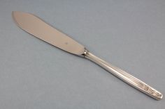 a large silver knife on a gray surface