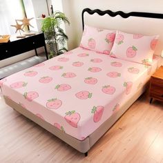 a bed with pink strawberry sheets and pillows