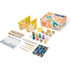 an assortment of crafting supplies including paint, paper and wooden pegs on a white background