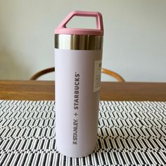 a pink and gold insulated water bottle sitting on top of a table