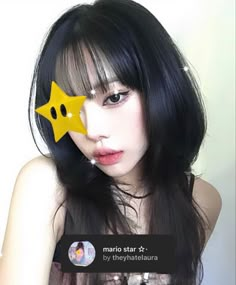 a woman with long black hair has a yellow star on her forehead